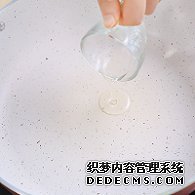 步驟圖:電陶爐開大火，煎炒鍋中倒入少許油。